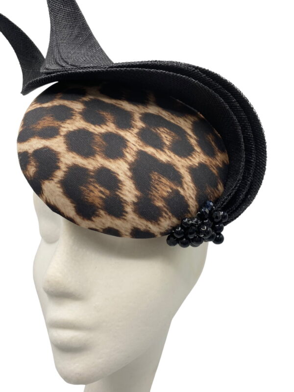 Leopard print headpiece with black swirl detail and black beads to the base of the swirl.